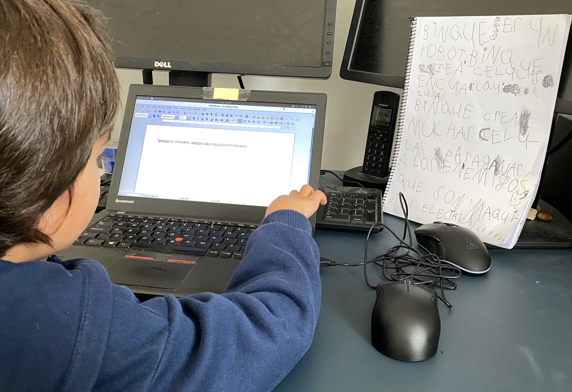 Kid typing text on a computer